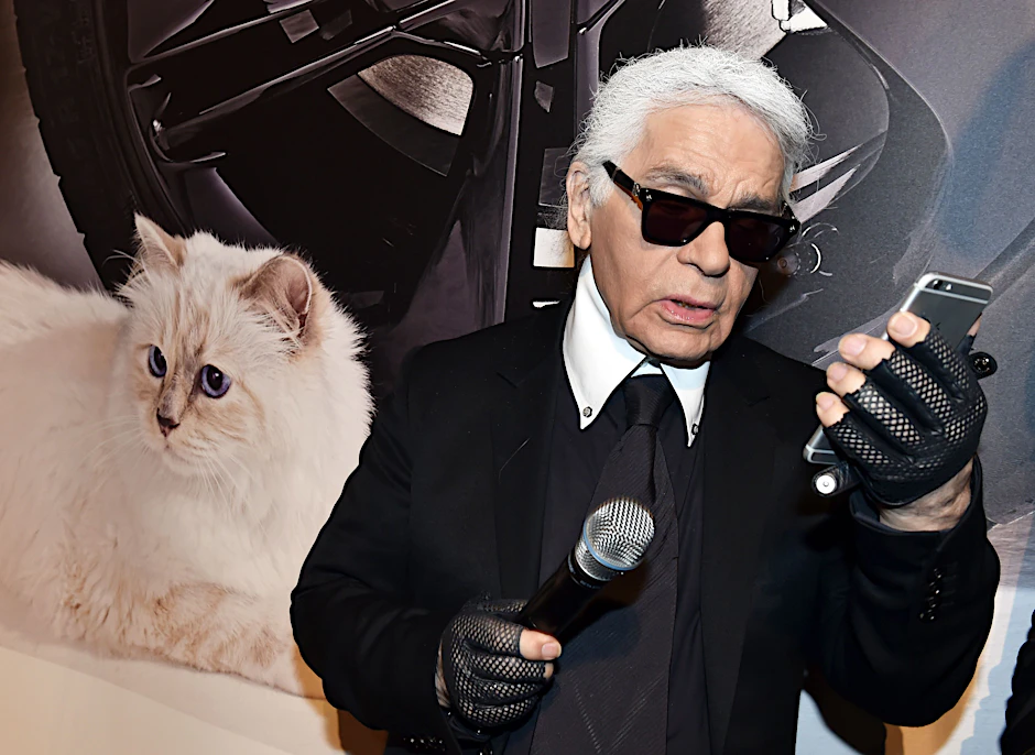 Der Modedesigner Karl Lagerfeld neben einem Foto seiner Birma-Katze Choupette. Jetzt, zwei Jahre nach seinem Tod, soll Lagerfelds Nachlass versteigert werden.