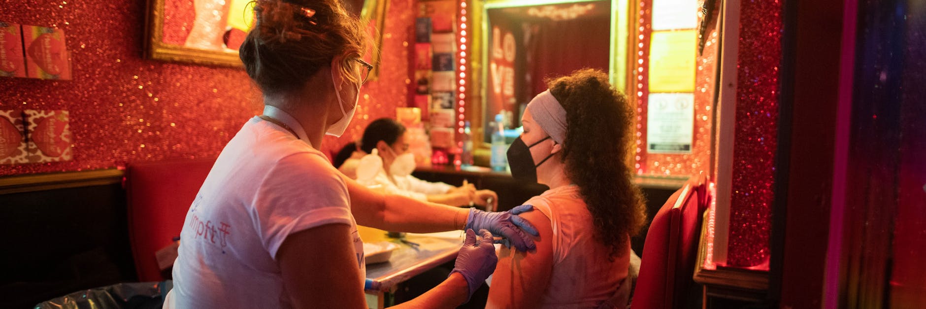 Impfaktion auf der Hamburger Reeperbahn: Eine junge Frau lässt sich im Rahmen der Aktion „Kiez-Piks“ in einer Bar impfen. Solche originelle Maßnahmen sollen bislang Unentschlossene zum Pieks bewegen. Doch reicht das?