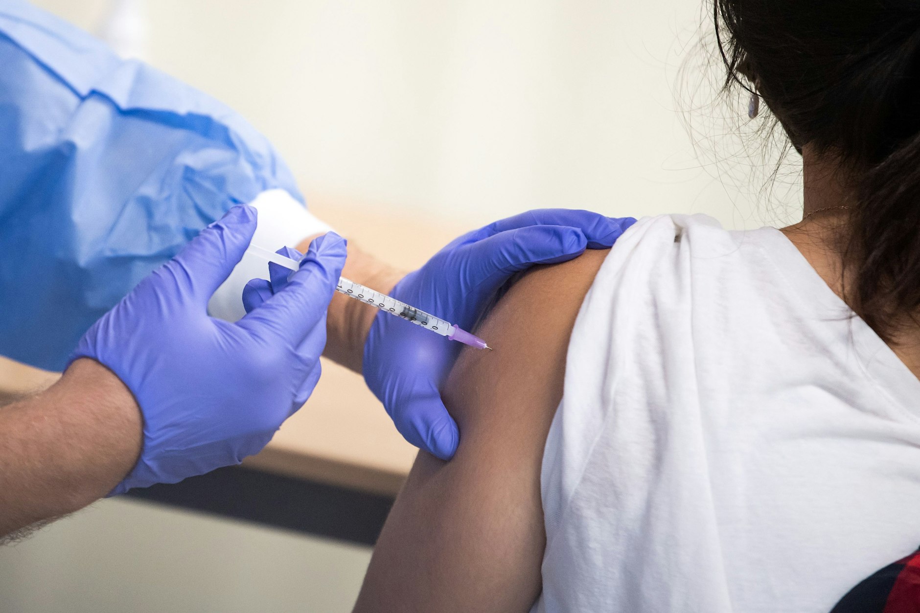 Eine junge Frau wird gegen Corona geimpft. 