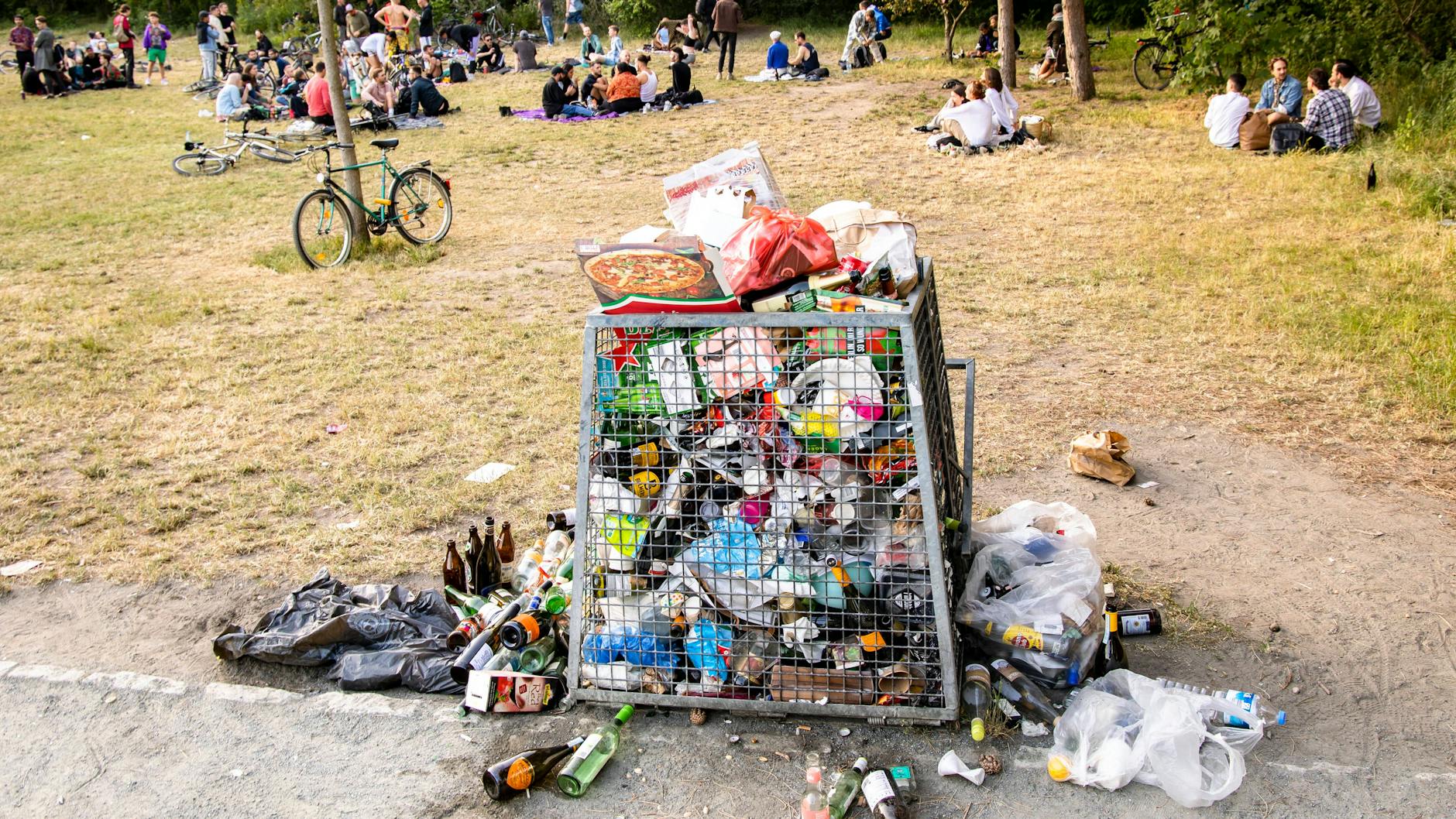 Ein Müllkorb voller Müll und Flaschen im Volkspark Hasenheide in Berlin am 13. Juni 2021. Ein sonniges Wochenende in Berlin hinterlässt Spuren. 