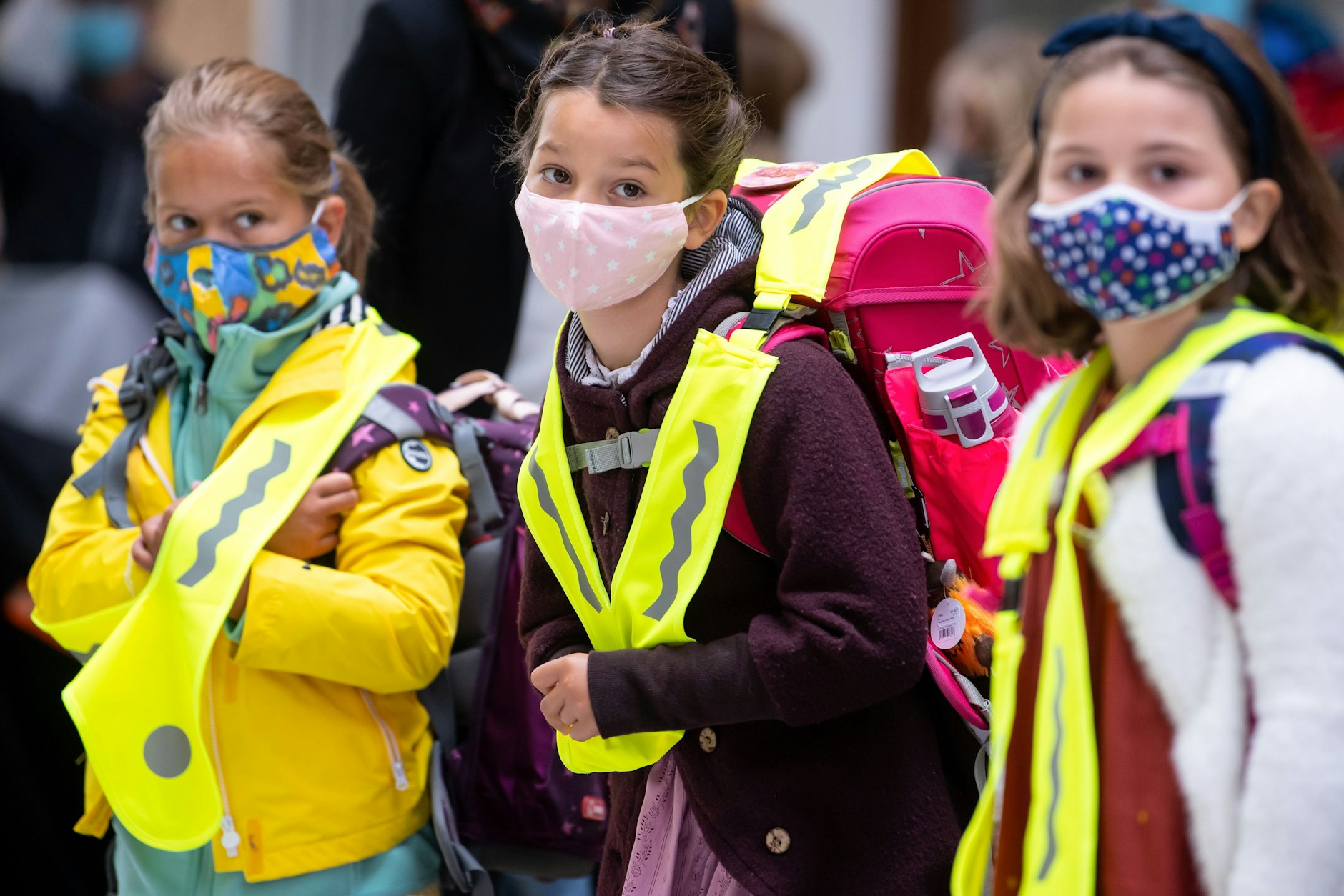 Maskierte Grundschulkinder auf dem Weg in die Schule.