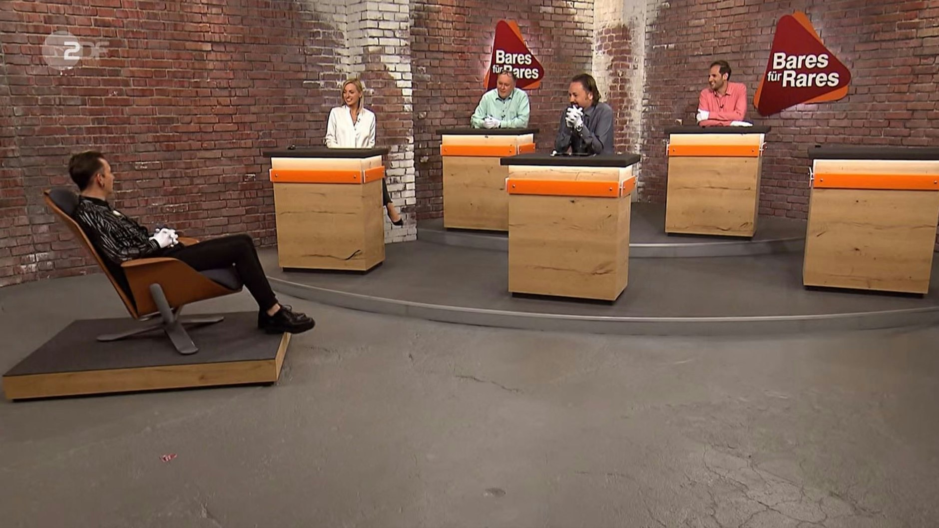 „Bares für Rares“-Händler Fabian Kahl im Händlerraum – hier sitzt er auf einem Exponat.