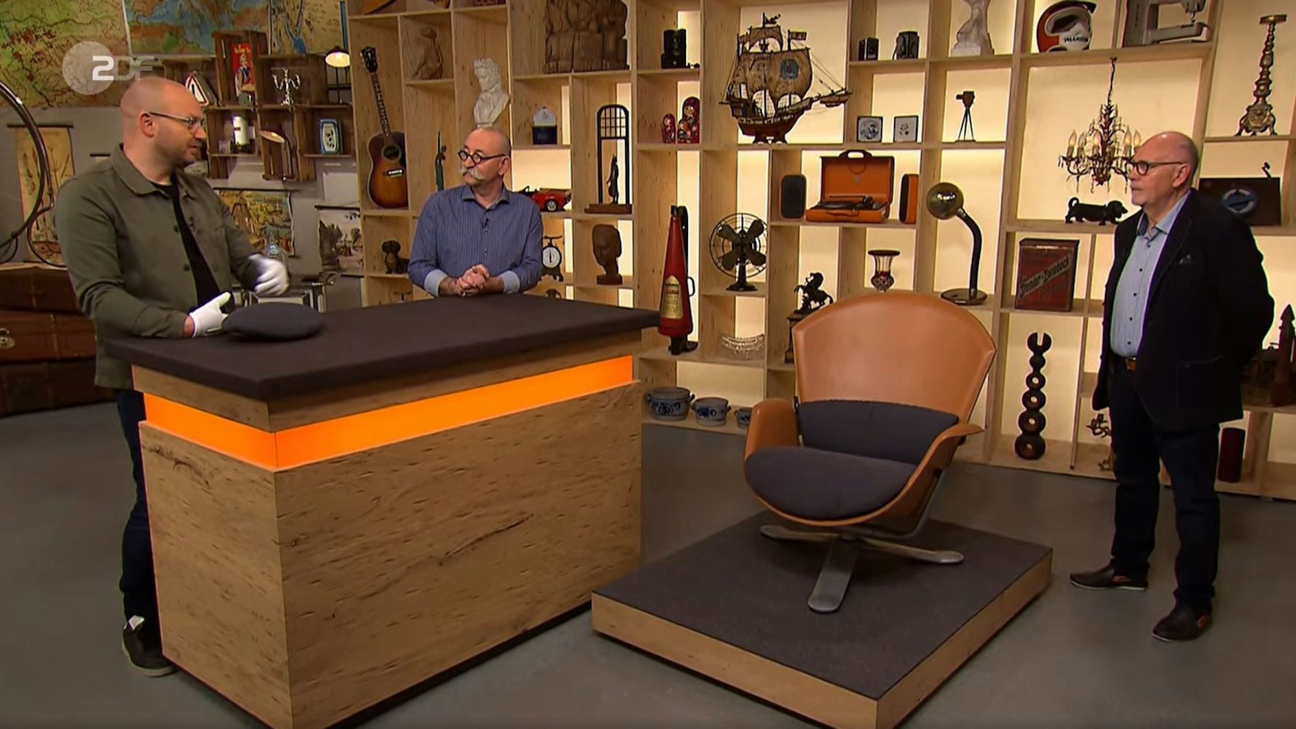 „Bares für Rares“: Horst Lichter und Manfred Klemper (r.) hören zu, was Experte Sven Deutschmanek über den Sessel zu erzählen hat.