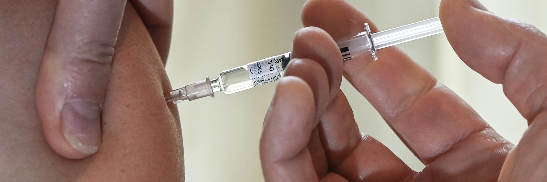 Ein Arzt impft eine Patientin gegen Grippe.