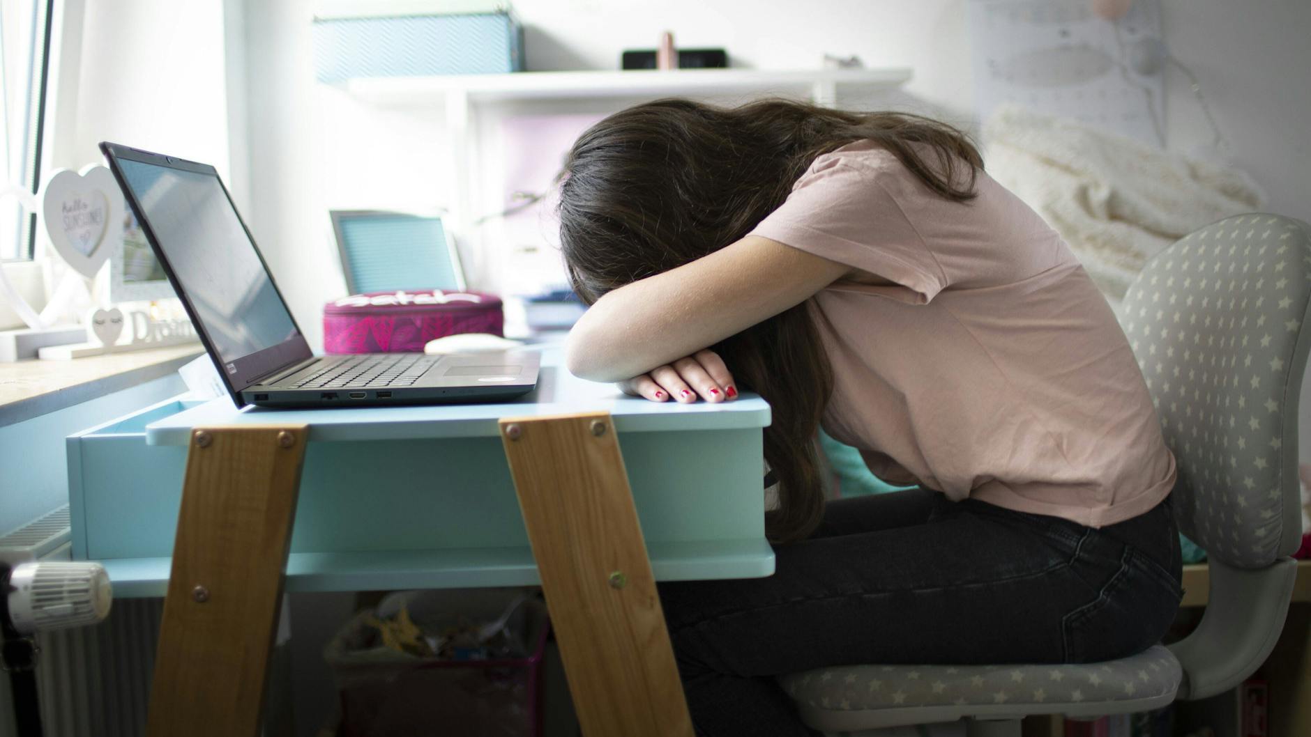 Ein Mädchen sitzt erschöpft vor einem Computer. Zu seelischen Spätfolgen gibt es nun die ersten belastbaren Zahlen. Sie sind alarmierend, sagen Experten.