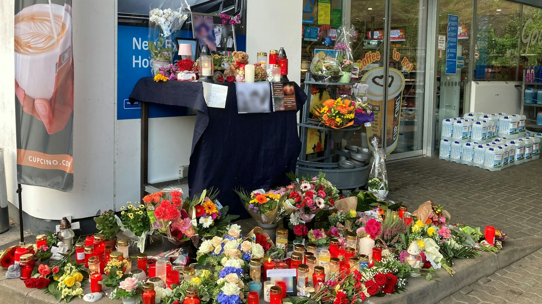 Blumen und Kerzen sind vor einer Tankstelle aufgestellt. Ein Angestellter der Tankstelle war am Samstagabend von einem mit einer Pistole bewaffneten Mann erschossen worden. Der Angestellte hatte den Kunden auf die Maskenpflicht hingewiesen, da dieser ohne Maske Bier kaufen wollte.&nbsp;