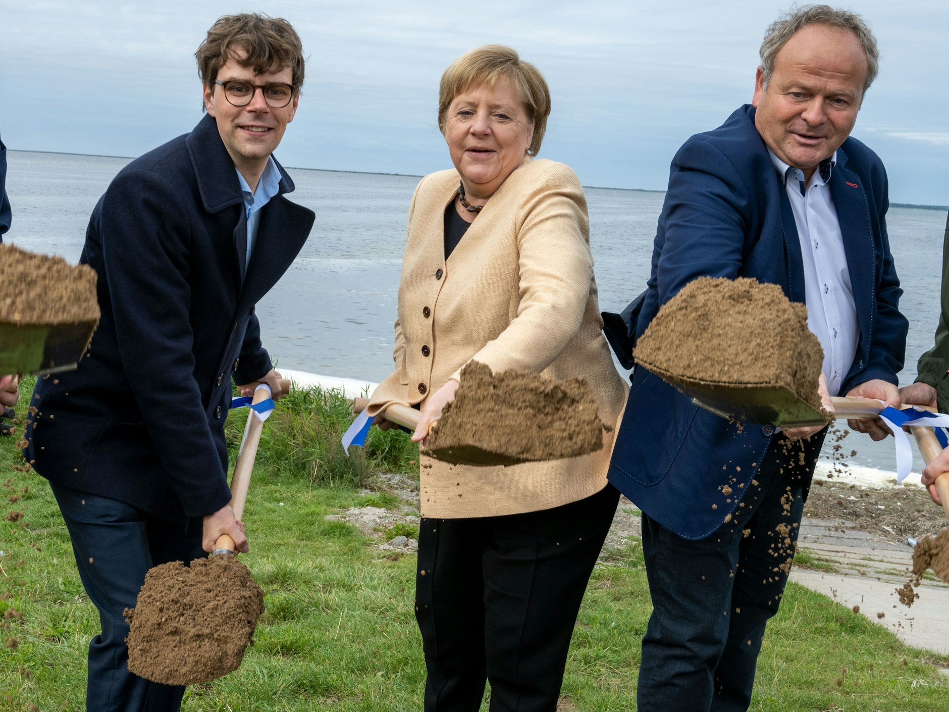 Bundeskanzlerin Angela Merkel, Georg Günther (links, CDU), Vorsitzender der Jungen Union Mecklenburg-Vorpommerns und der Bürgermeister der Gemeinde Ummanz, Holger Kliewe (CDU) auf der Insel Ummanz beim ersten Spatenstich zum Ausbau Radweges in der Gemeinde.