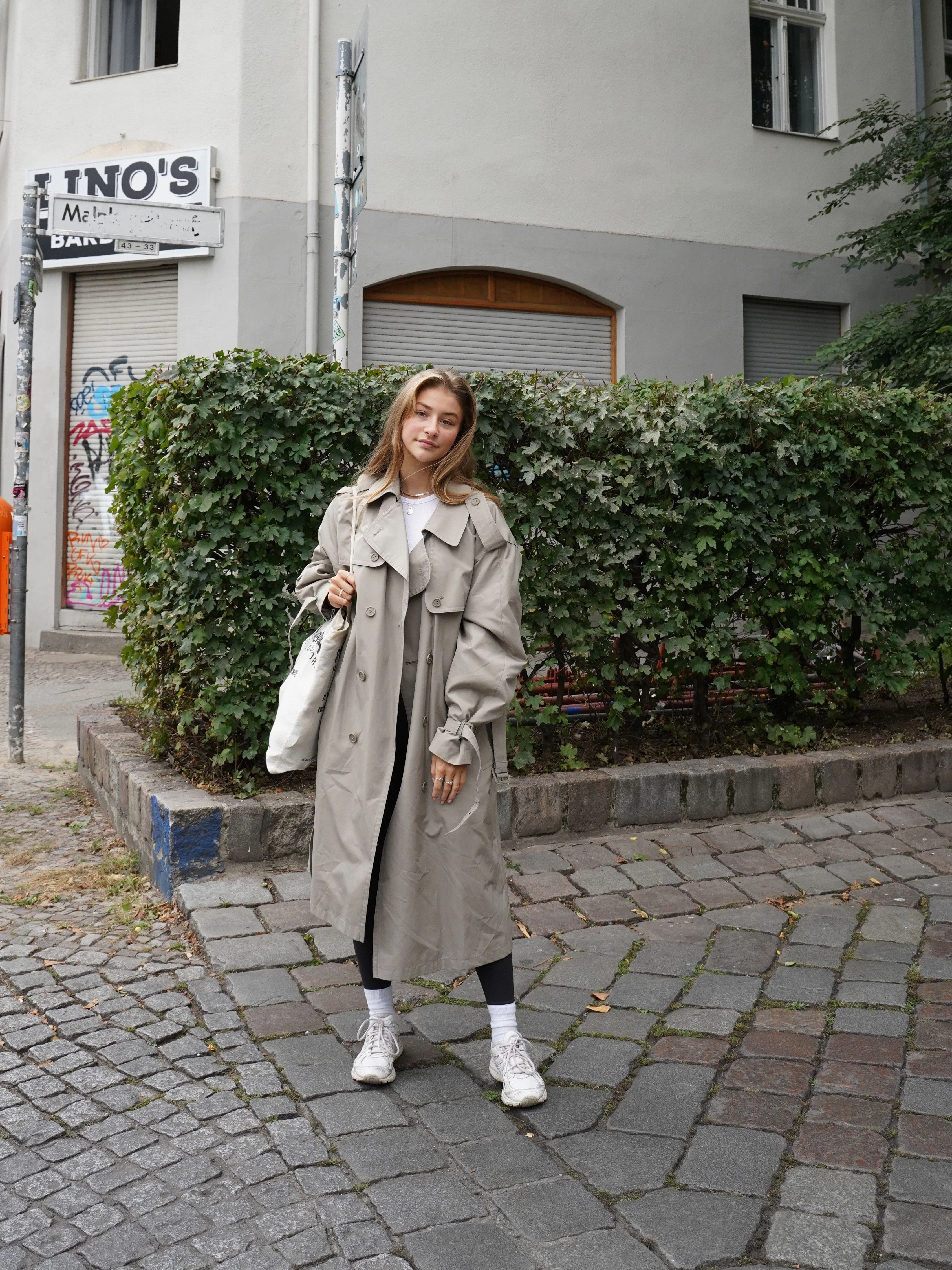 Freya studiert Grafikdesign am Mediencollege in Mitte. Seit sie aus Köln nach Berlin gezogen ist, wohnt sie in Wedding und will hier nicht mehr weg. Unter dem Vintage-Trenchcoat trägt sie Basics von H&M und Zara, dazu weiße Socken und Asics.