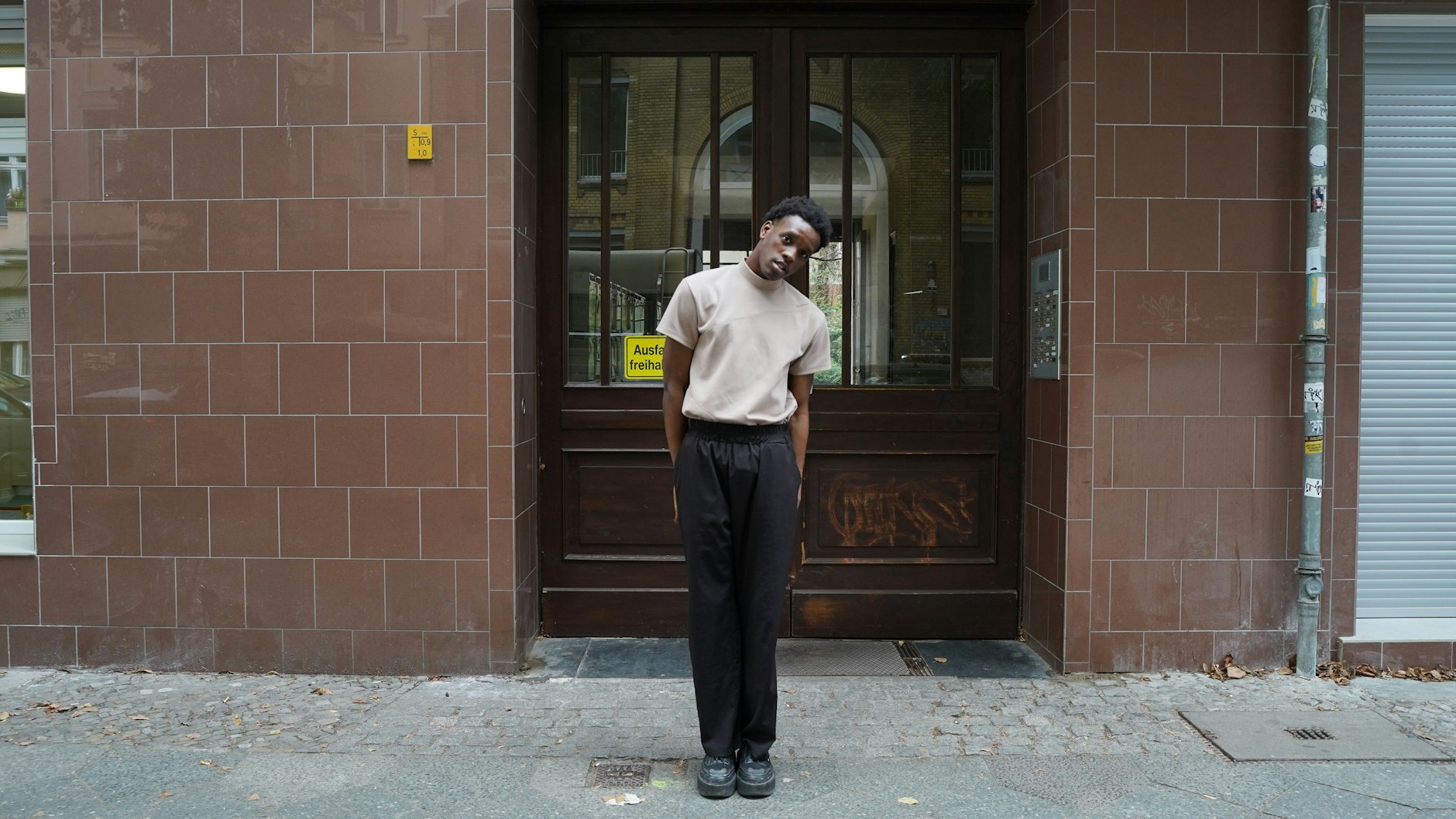 Der Franzose Raphael ist Model und Schauspieler. Er lebt seit einem Jahr in Berlin und besucht gerade Freunde in der Malplaquetstraße. Raphael posiert im Oberteil von ESC Studio, einer Hose von Seventh und <em>bulky</em> Schuhen von Rombaut.