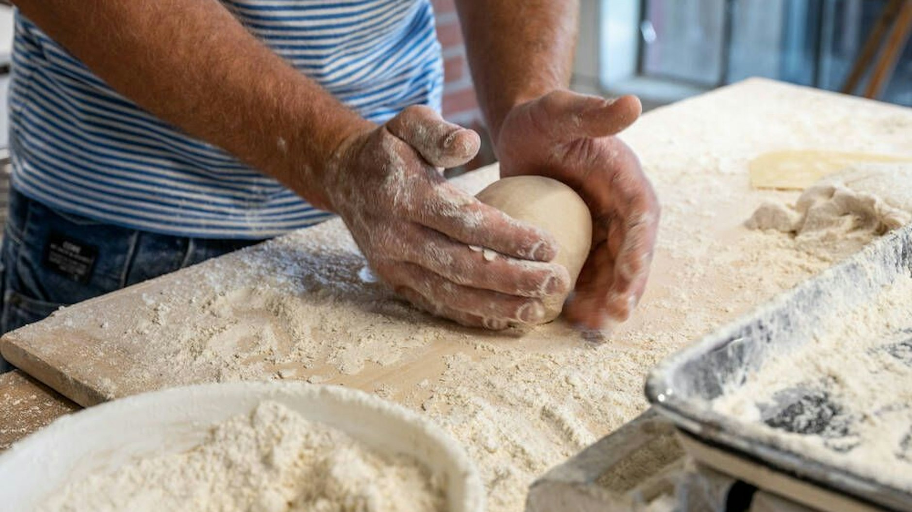 Der Teig wird mit feuchten Händen in Form gebracht – dann klebt er weniger an den Fingern.