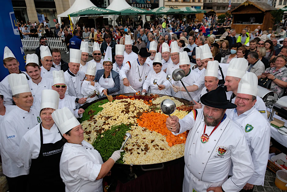 Essen ist fertig! Köche des Internationalen Kochkunstvereins zu Leipzig stehen auf dem Marktplatz um ihre Riesen-Pfanne Leipziger Allerlei herum.&nbsp;