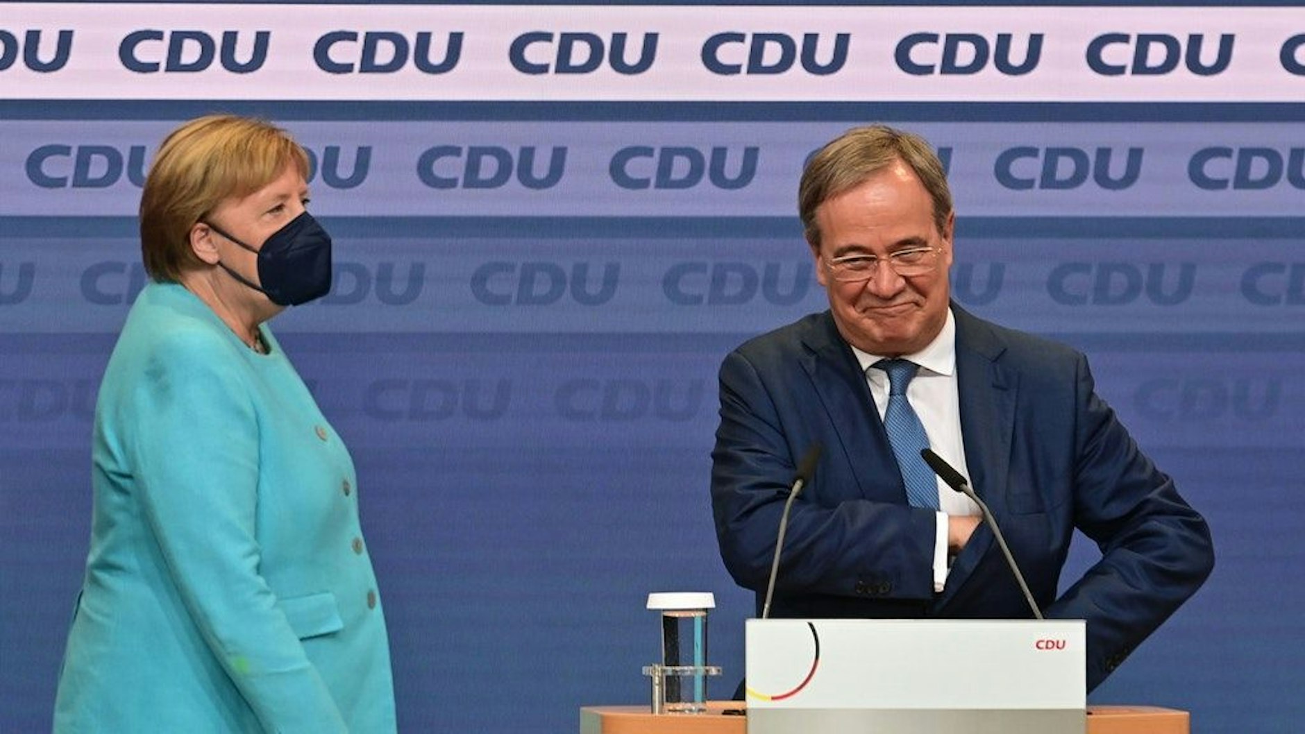 Kanzlerkandidat Armin Laschet (CDU) spricht nach Bekanntgabe der ersten Prognosen auf der Wahlparty der Union im Konrad-Adenauer-Haus. Links neben ihm: Angela Merkel.