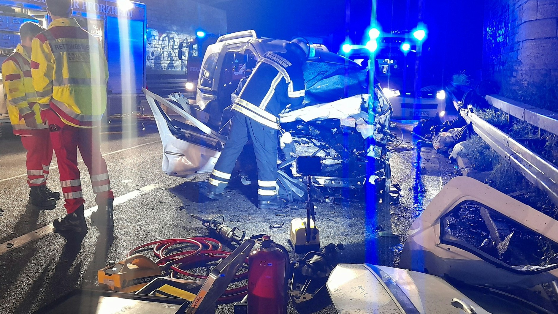 Feuerwehrleute untersuchen das Autowrack, mit dem ein Falschfahrer zusammengestoßen war.