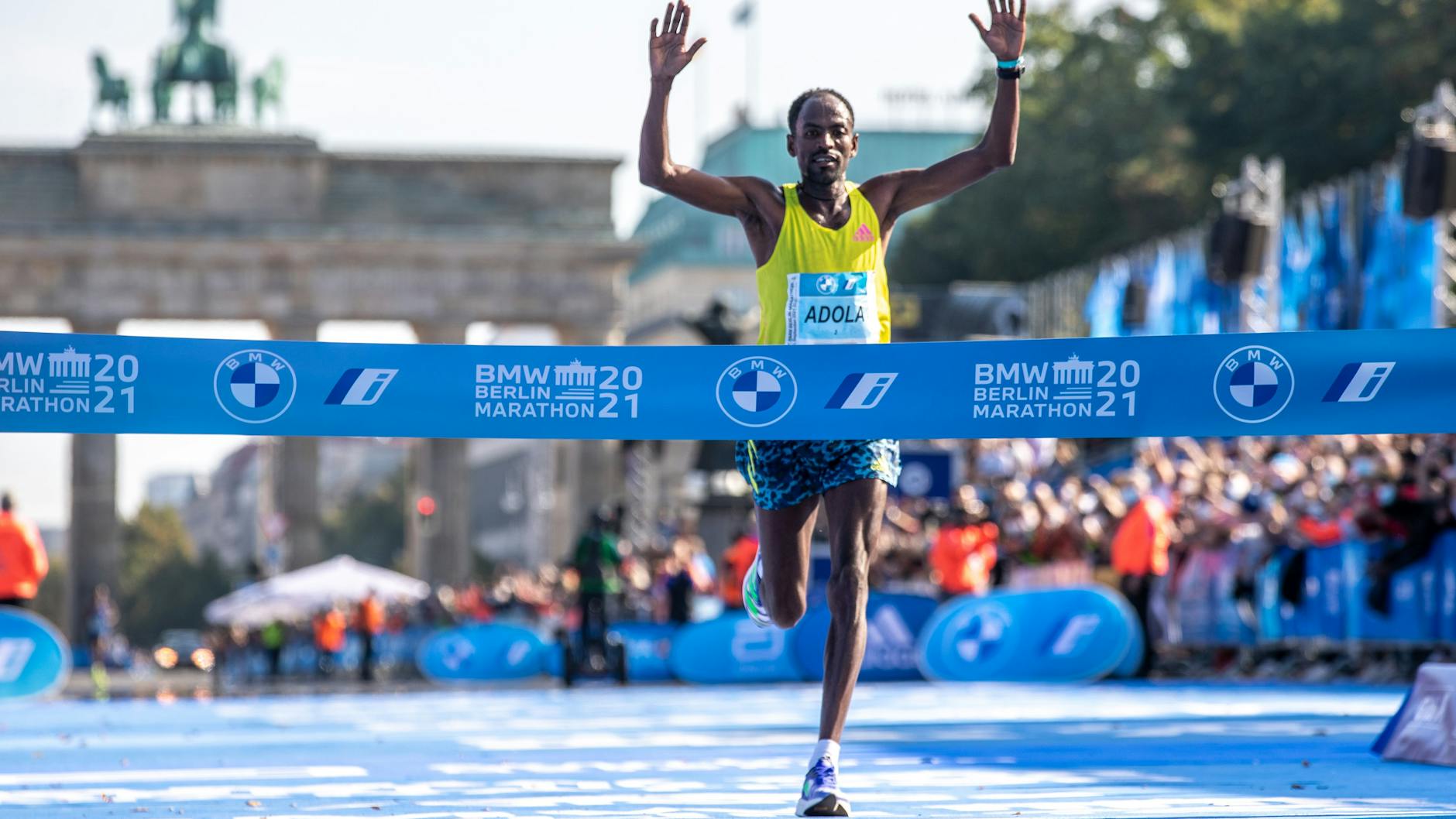 Die Zuschauer jubeln Guye Adola aus Äthiopien zu, der als Erster im Ziel des Berlin Marathons auftaucht.