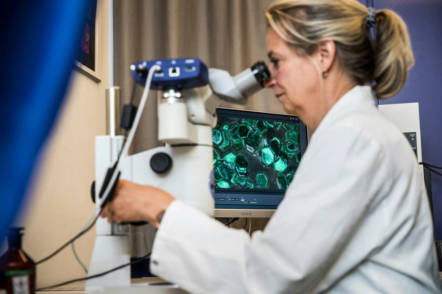 Auf dem Bildschirm des Mikroskops werden die einzelnen Lackpigmente sichtbar.