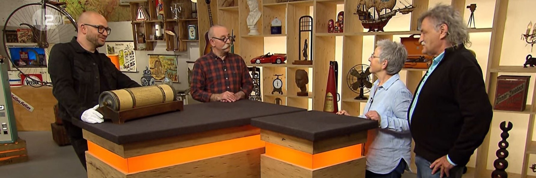 „Bares für Rares“-Experte Sven Deutschmanek versucht Moderator Horst Lichter und dem Ehepaar Germann die Rechenwalze zu erklären.