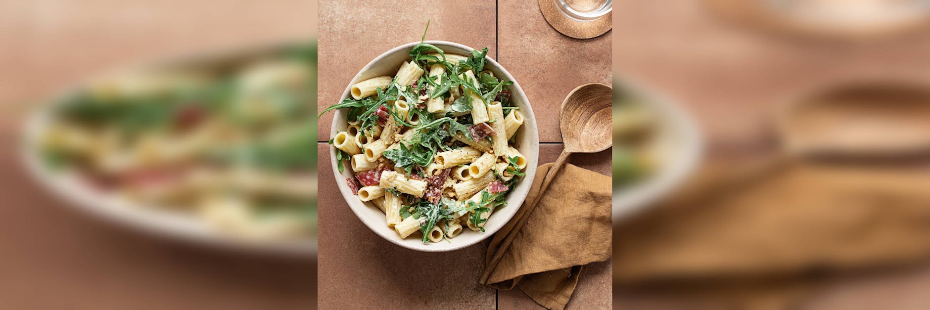 Ein mediterraner Nudelsalat mit Rucola, Pinienkernen und getrockneten Tomaten.