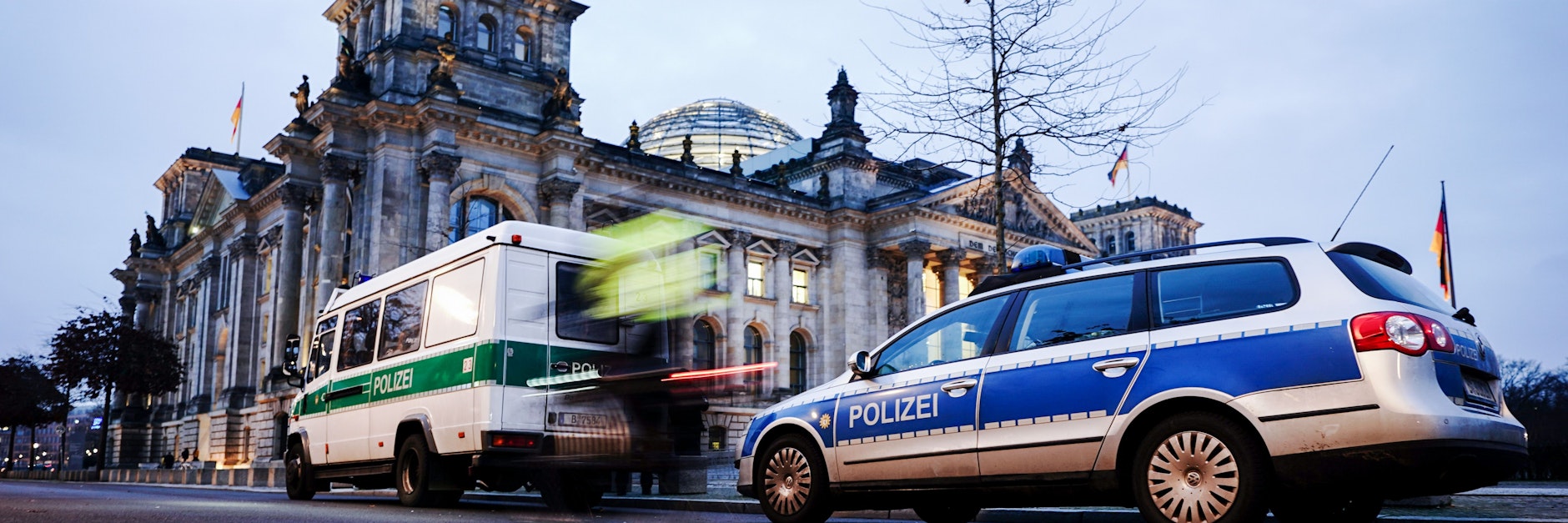 Fahrzeuge der Polizei stehen am frühen Morgen vor dem Reichstagsgebäude. 