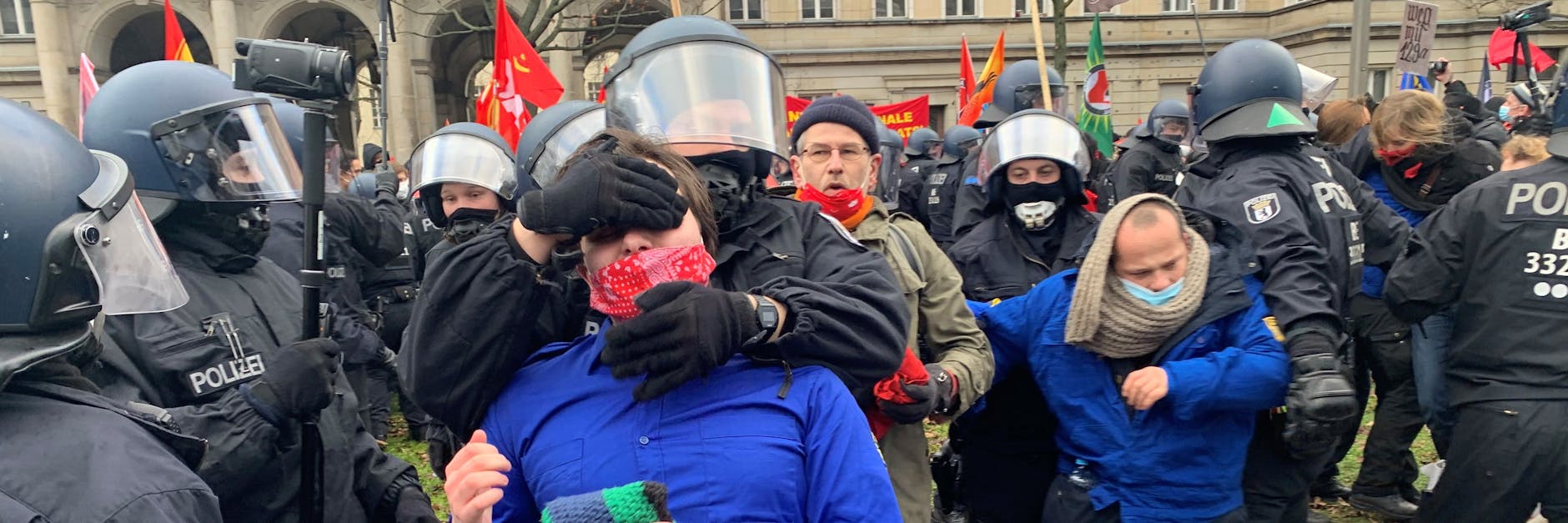 Eine Frau und ein Mann in FDJ-Blusen werden festgenommen. Der Mann bekam vom Polizisten, der ihn abführte, zu hören: „Entspann dich und komm einfach mit mir mit.“