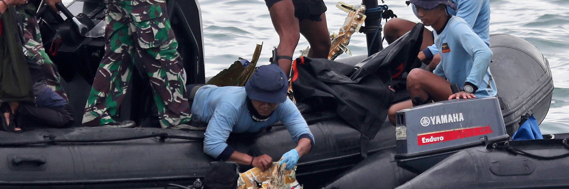 Taucher der indonesischen Marine ziehen während einer Suchaktion ein Flugzeugteil aus dem Wasser. 