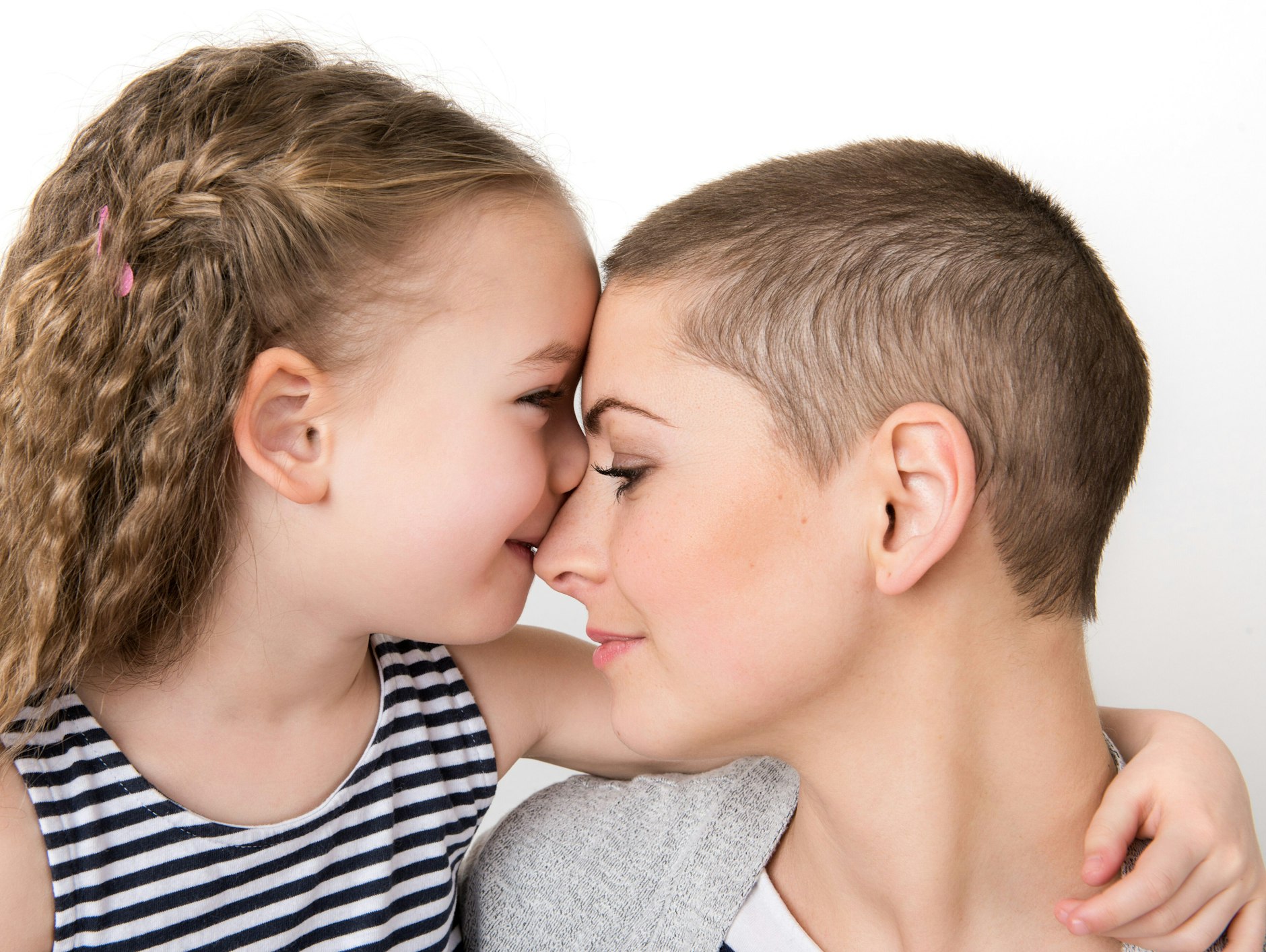 Zärtlich umarmt das kleine Mädchen seine Mutter, die gerade durch eine Chemotherapie gegangen ist. (Symbolfoto)