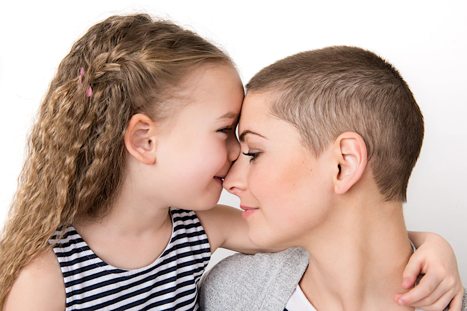 Zärtlich umarmt das kleine Mädchen seine Mutter, die gerade durch eine Chemotherapie gegangen ist. (Symbolfoto)