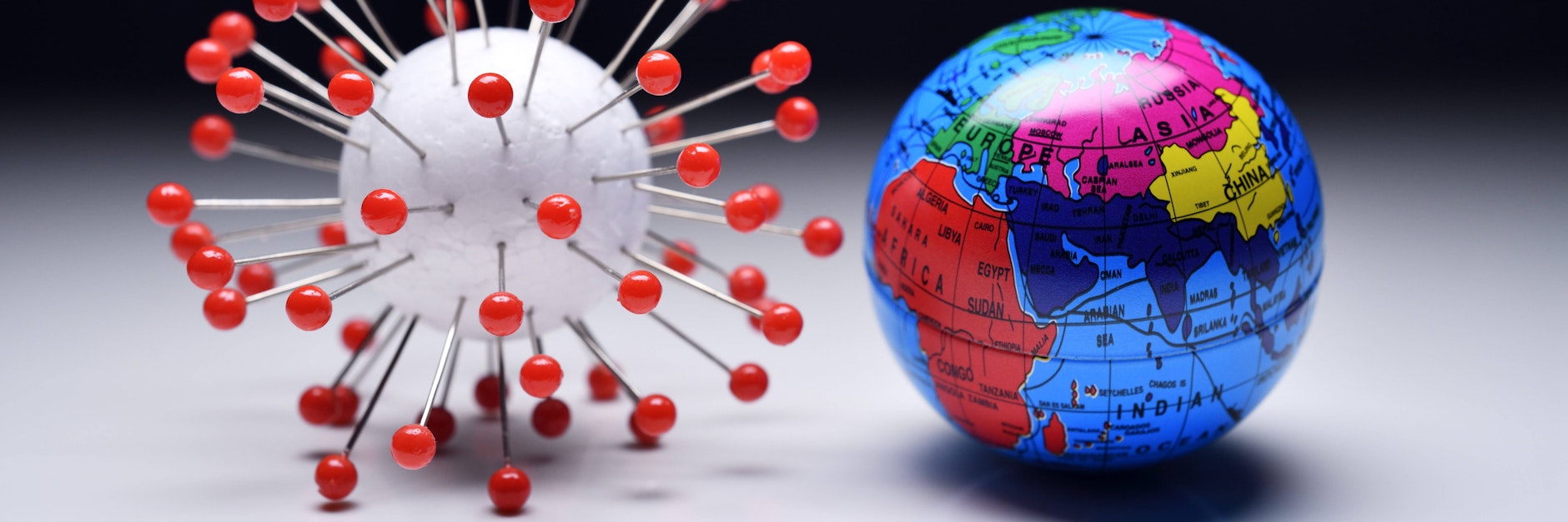 Coronavirus-Modell und Erdkugel (Symbolfoto).