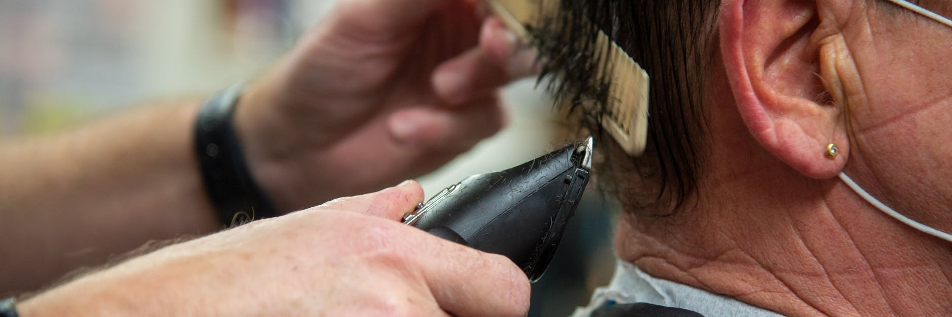 Einem Mann werden die Haare mit einer Maschine geschnitten. (Symbolbild)