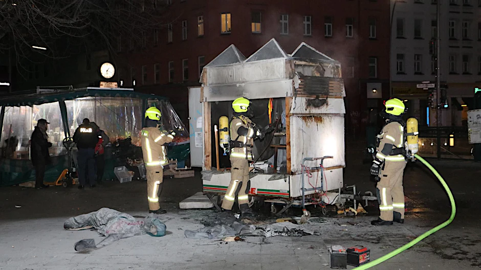 Feuerwehrleute vor dem abgebrannten Anhänger