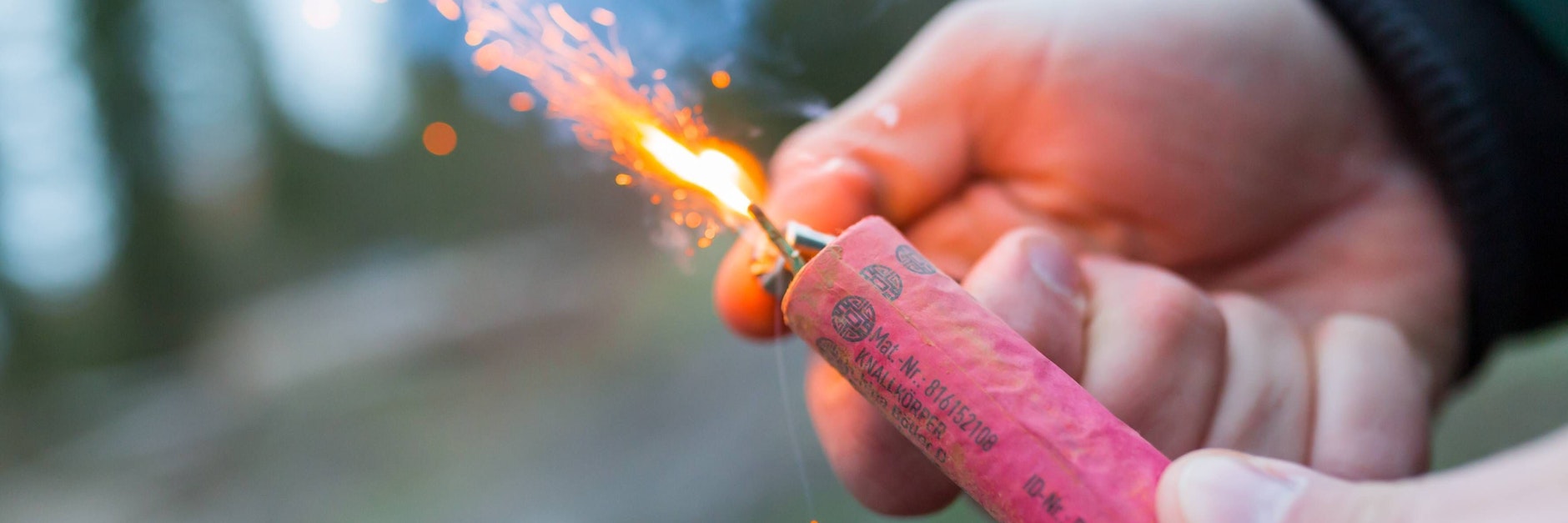 Ein Böller wird in der Hand gezündet.