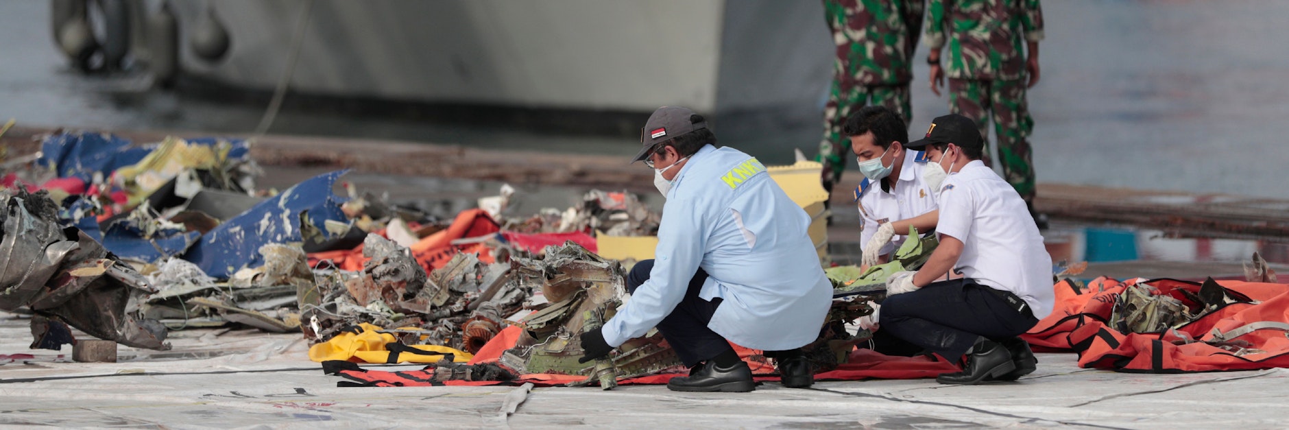 Spezialisten untersuchen die Trümmerteile des abgestürzten Flugzeugs. 