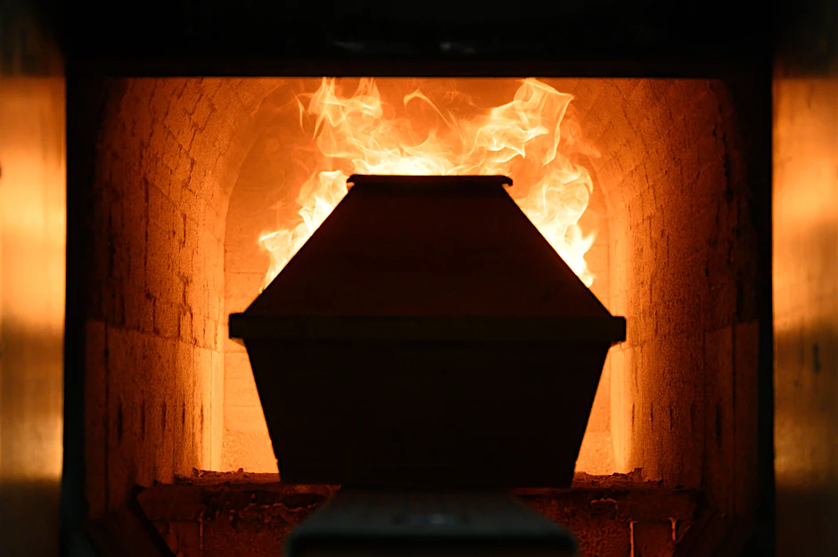 Ein Sarg fährt in einem Krematorium in Dresden in den Einäscherungsofen.