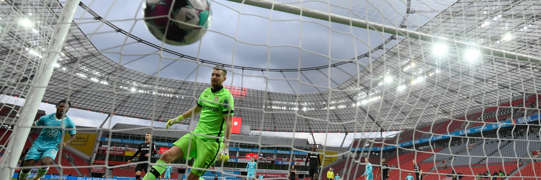Wolfsburgs Ridle Baku (l.) trifft zum 1:0 und Bayers Keeper Lukas Hradecky kann dem Ball nur hinterherschauen. 