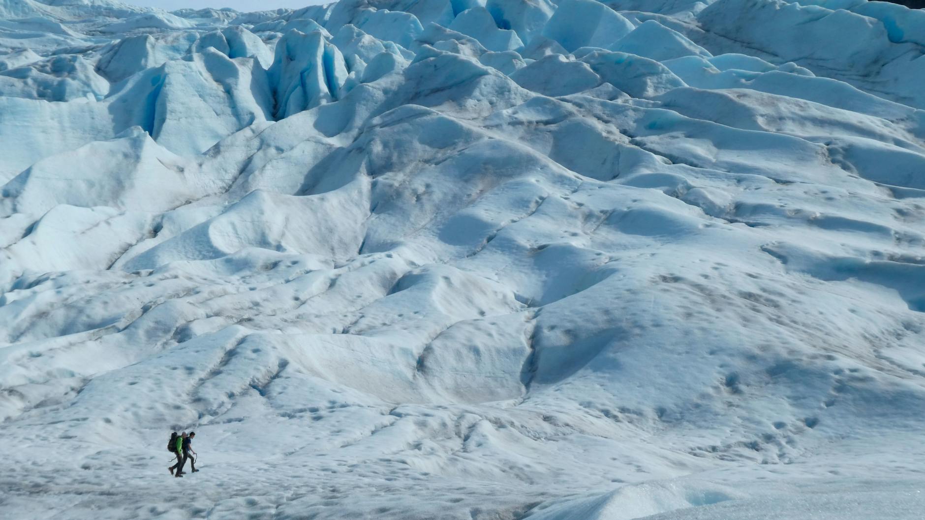 Zwei Menschen wandern auf einem Gletscher in Alaska. Einer aktuellen Studie zufolge sind vom Jahr 1994 bis 2017 rund 28 Billionen Tonnen Eis geschmolzen.