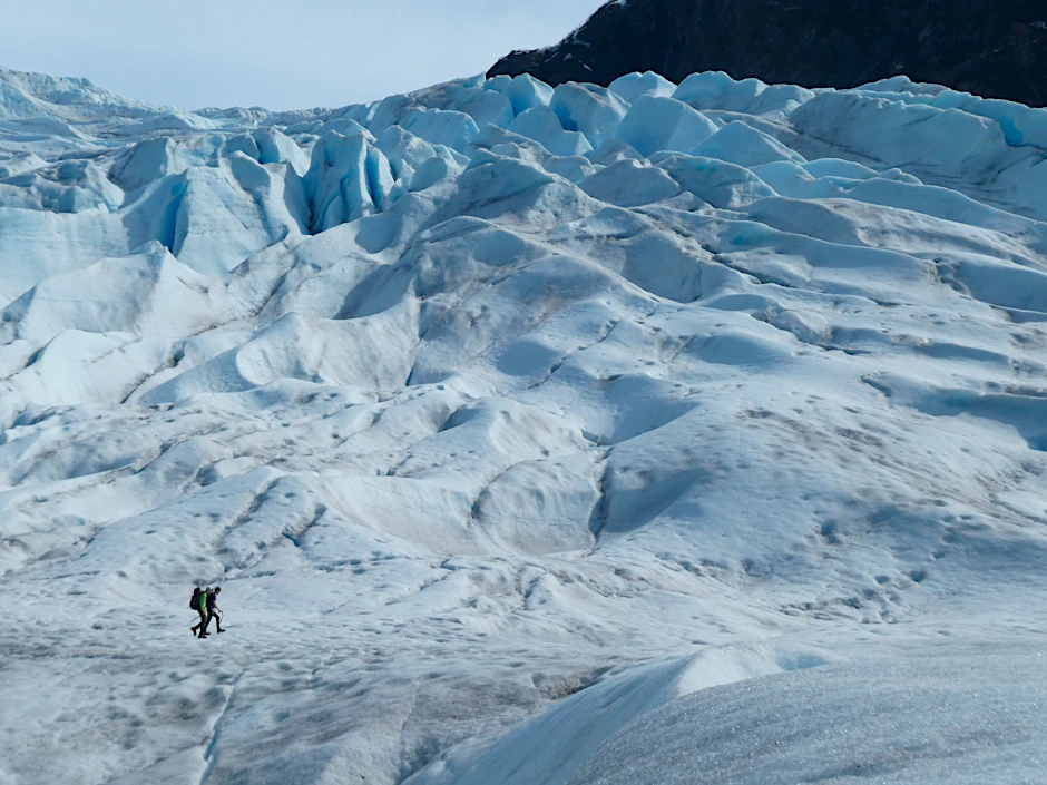 Zwei Menschen wandern auf einem Gletscher in Alaska. Einer aktuellen Studie zufolge sind vom Jahr 1994 bis 2017 rund 28 Billionen Tonnen Eis geschmolzen.