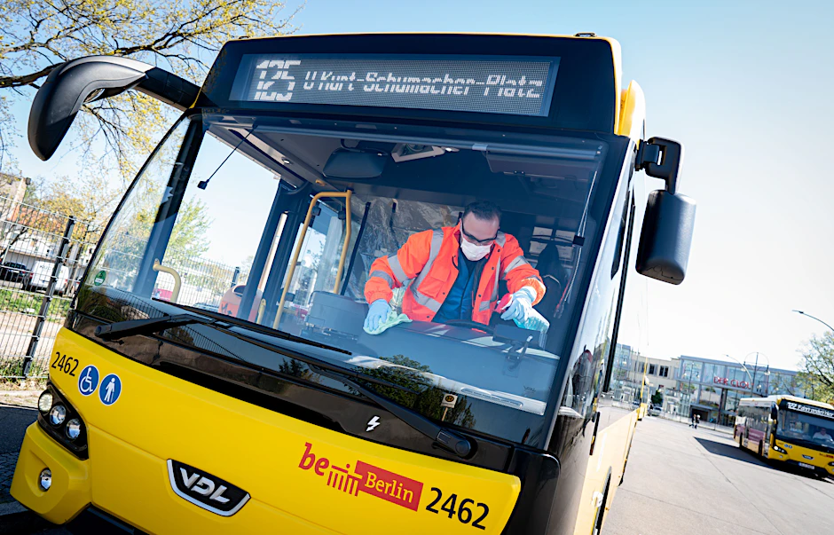 Ein BVG-Mitarbeiter säubert den Fahrerplatz in einem Bus.&nbsp;