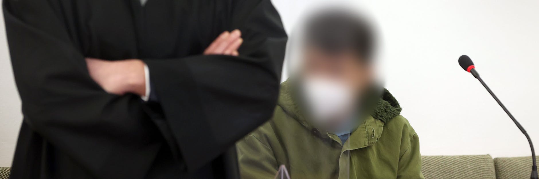 Der Angeklagte sitzt im Landgericht auf der Anklagebank. Dem Mann wird vorgeworfen, im Juli 2020 seine Ehefrau vor den Augen mehrerer Schüler in einem Linienbus erstochen zu haben.