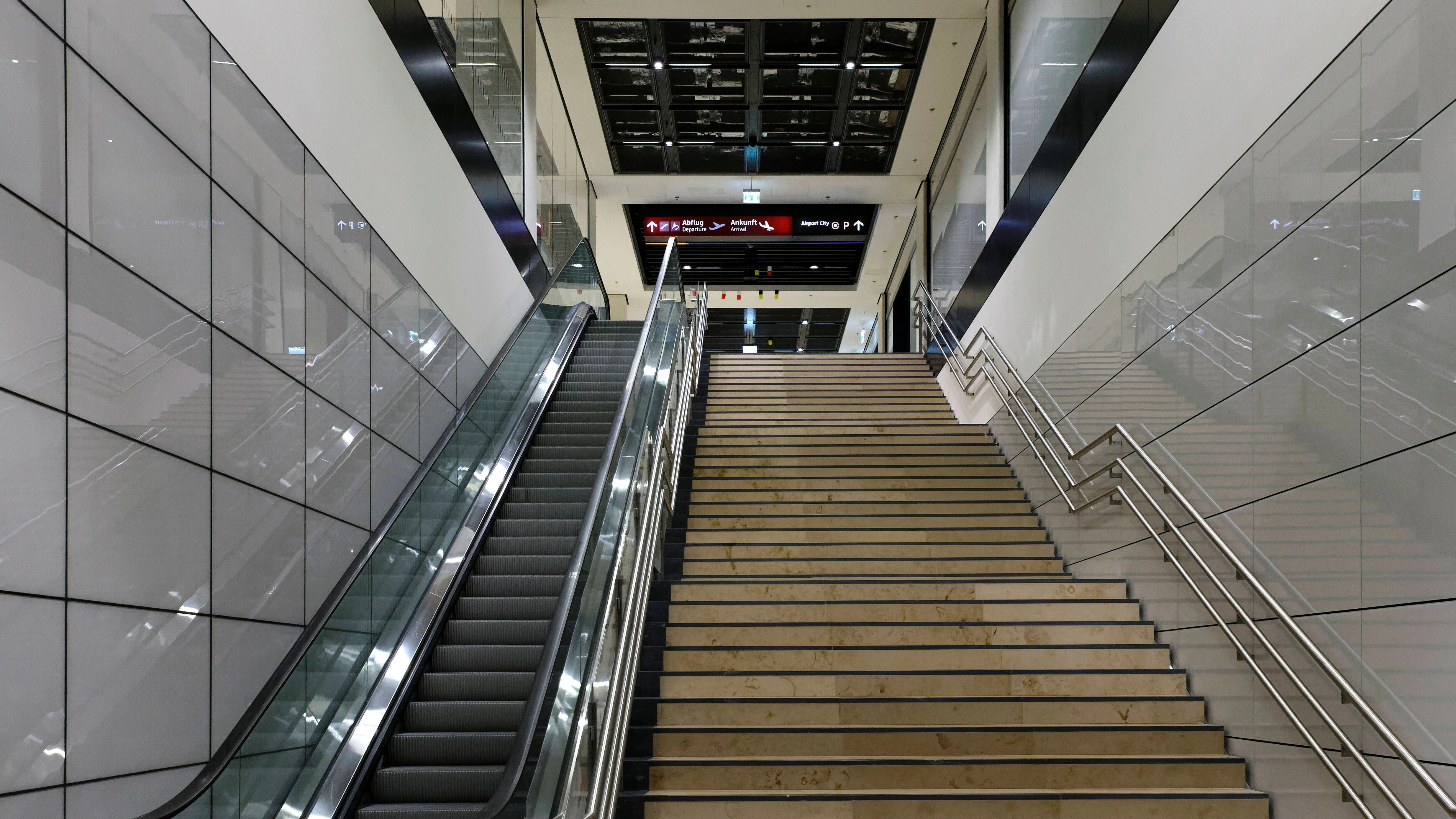 Im Flughafenbahnhof gibt es nur aufwärts führende Fahrtreppen. Ursprünglich sollten die Aufgänge breiter ausfallen, dann hätte es auch Platz für Fahrtreppen nach unten gegeben. Doch die Flughafengesellschaft, Bauherr des Bahnhofs, wollte sparen.&nbsp;