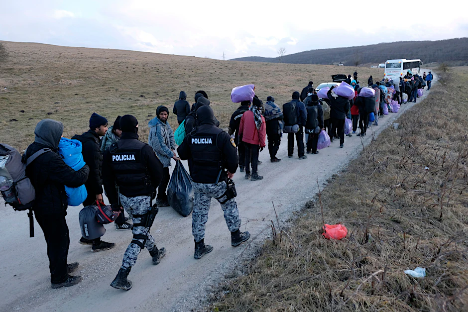 Polizeibeamte begleiten obdachlose Migranten in Bosnien-Herzegowina.