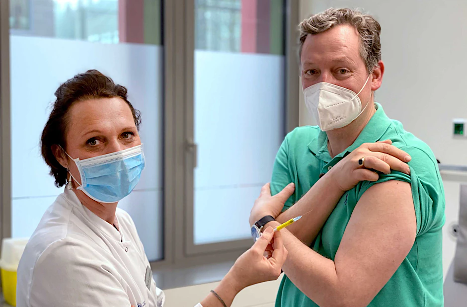 Arzt und Wissenschaftsjournalist Eckart von Hirschhausen steht neben Studienleiterin Professor Clara Lehmann (Uniklinik Köln), die eine Spritze in der Hand hält. Von Hirschhausen hat für eine TV-Doku (Montag, 1. Februar, 20.30 Uhr, ARD) an einer Impfstudie in Köln teilgenommen.&nbsp;&nbsp;