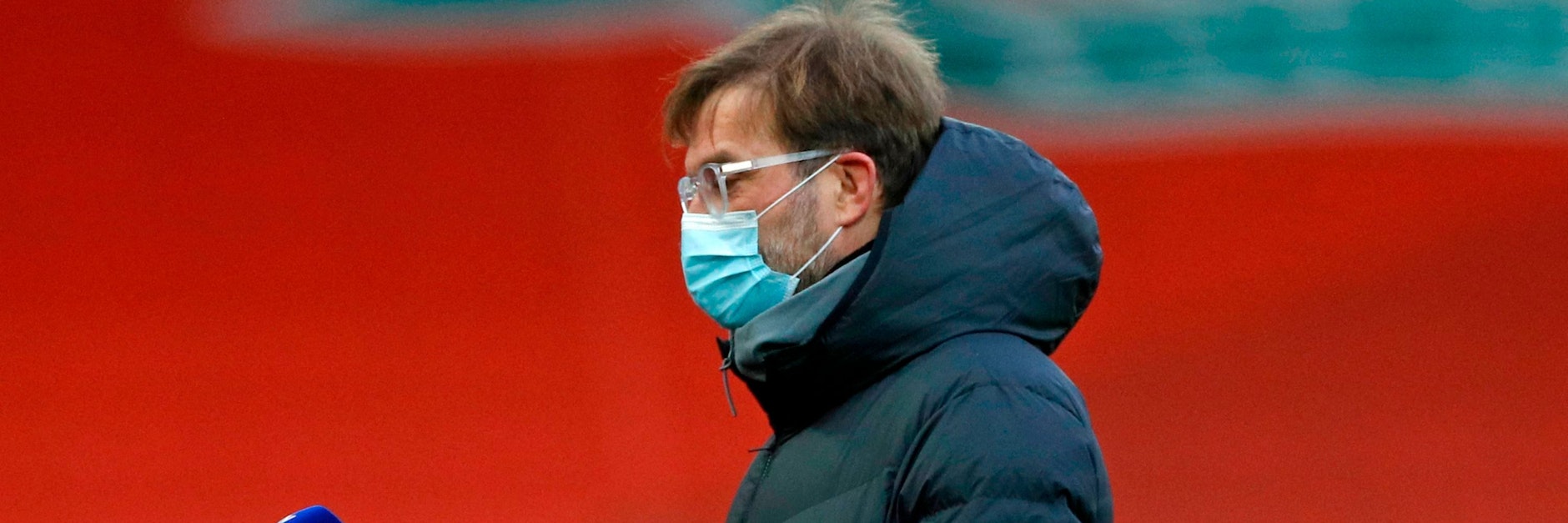 Liverpool-Coach Jürgen Klopp trägt wegen der Corona-Pandemie eine OP-Maske während eines Interviews.