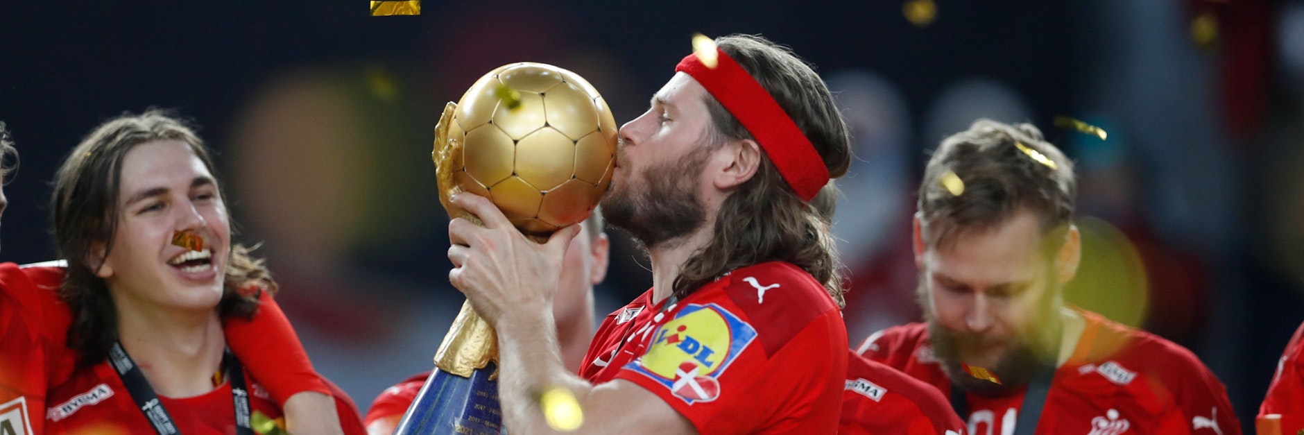 Fuchs Jacob Holm (l.) schaut ganz begeistert zu, wie Superstar Mikkel Hansen den WM-Pokal küsst.