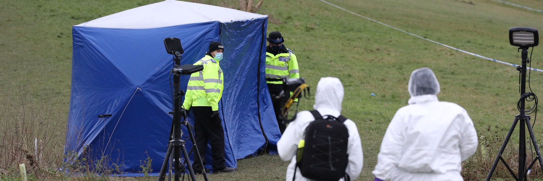 Zwei Gerichtsmediziner gehen in Richtung eines Zeltest am Tatort auf dem Bugs Bottom Feld.&nbsp;&nbsp;