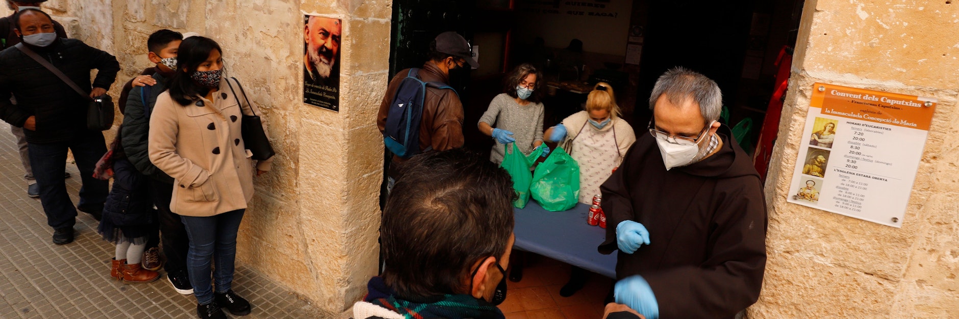 Essensausgabe für Arme und Obdachlose in Palma de Mallorca: Pfarrer Gil Pares (r.) begrüßt Bedürftige am Weihnachtstag.