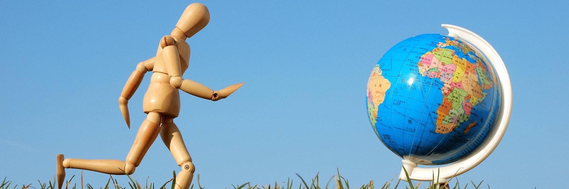 Eine&nbsp;Gliederpuppe vor einem Globus (Symbolfoto).