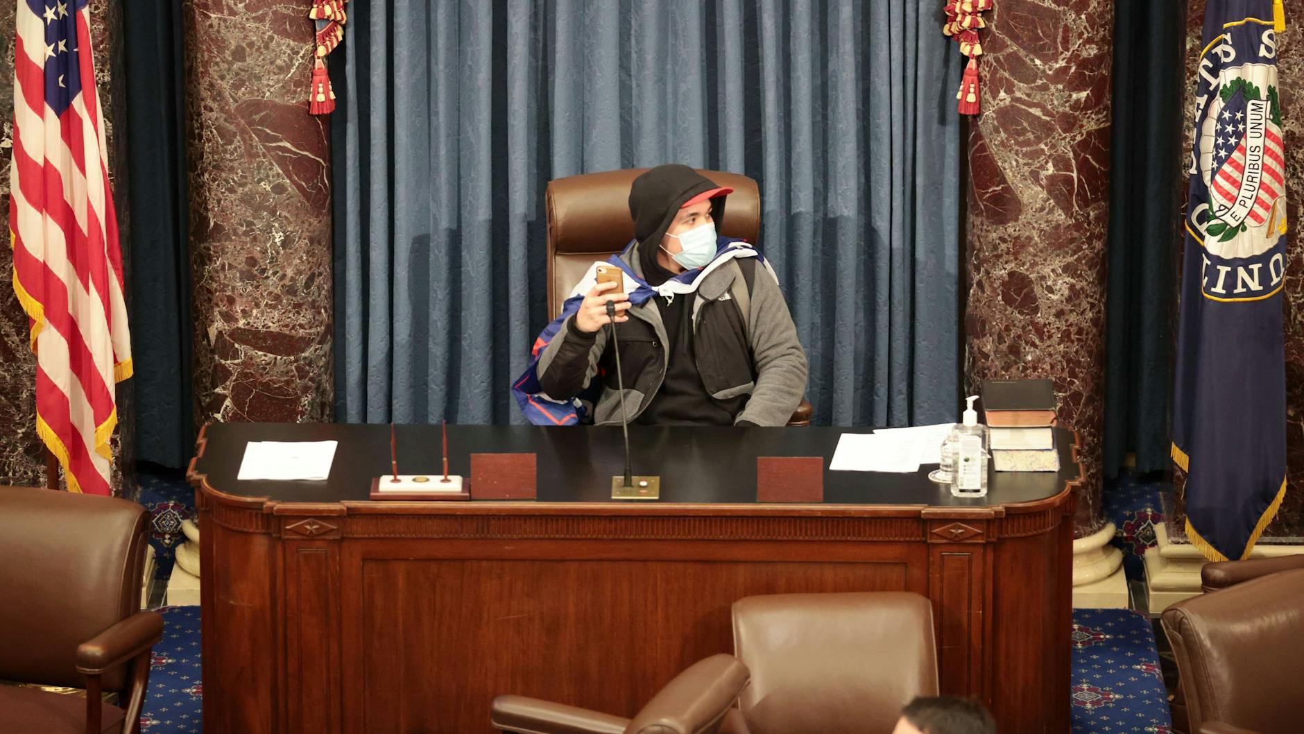 Einer der Eindringlinge nimmt in der Senatskammer Platz.