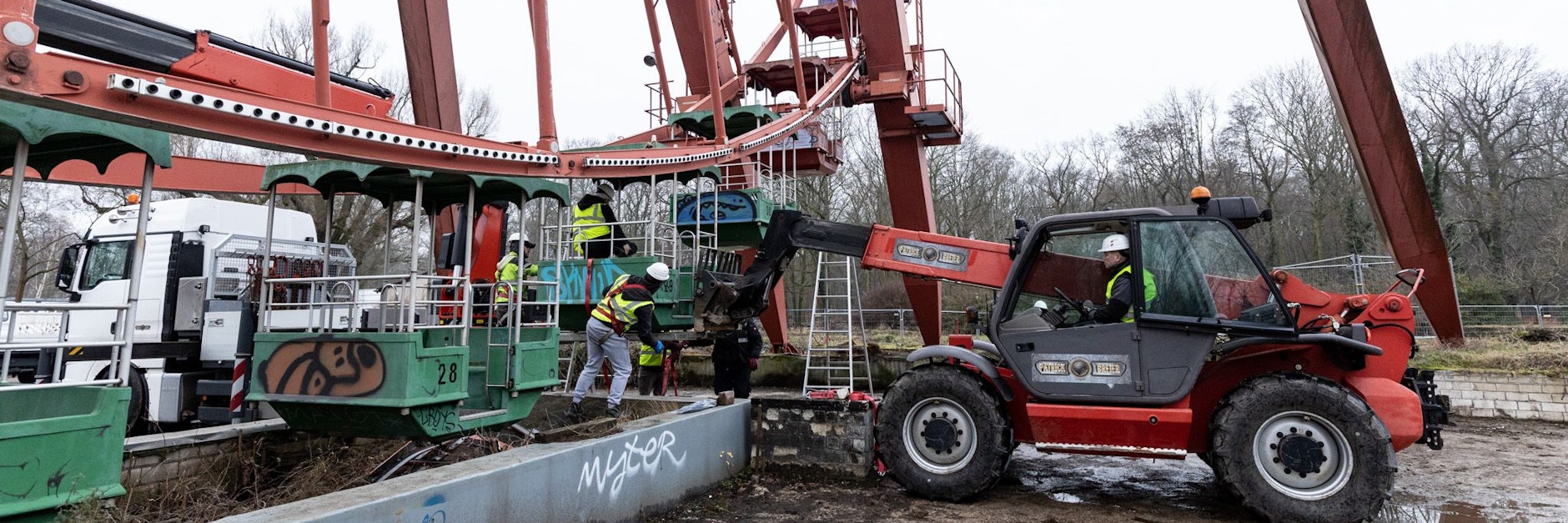 Die Arbeiten am Riesenrad beginnen. Hier wird die erste Gondel ausgehängt.