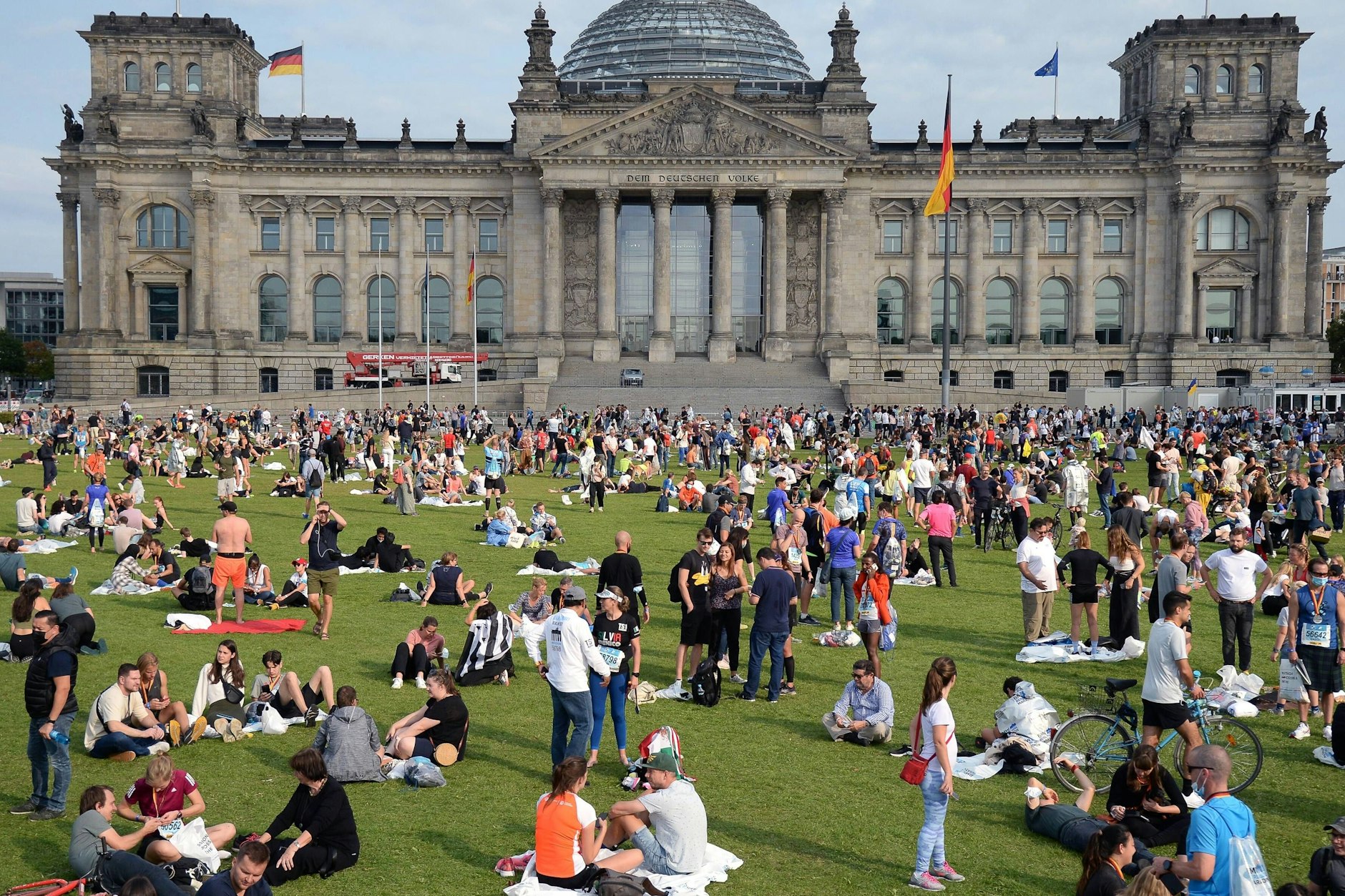 Die Ruhe nach dem Chaos am Sonntag: Berlinerinnen und Berliner warten auf die Wahlergebnisse auf der Wiese vor dem Reichstag.