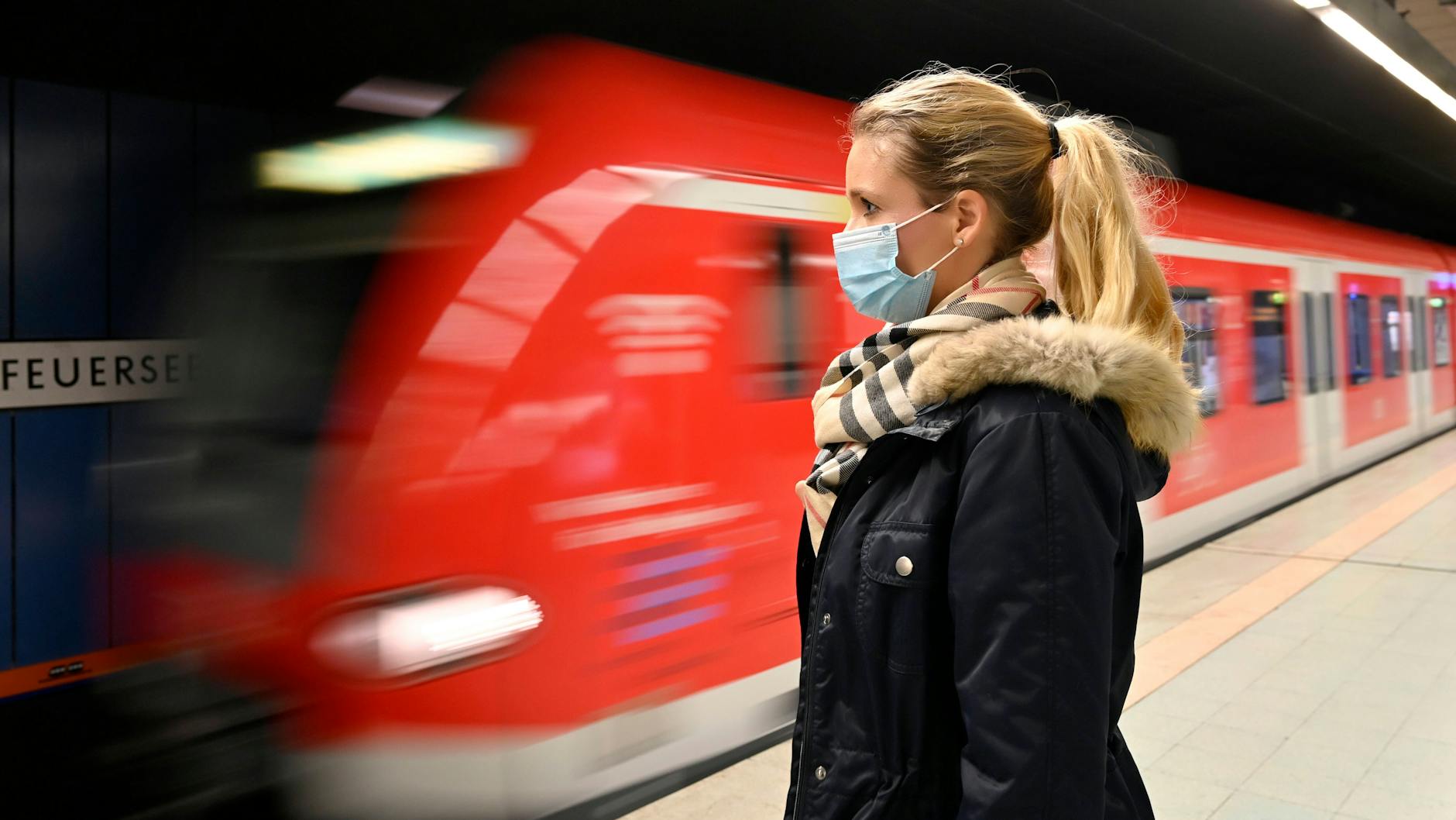 Ein Frau mit Mund-Nasen-Schutz wartet auf einen Zug. Auch in Zukunft müssen Zugreisende in Deutschland keine Corona-Tests oder Impfpässe vorzeigen.