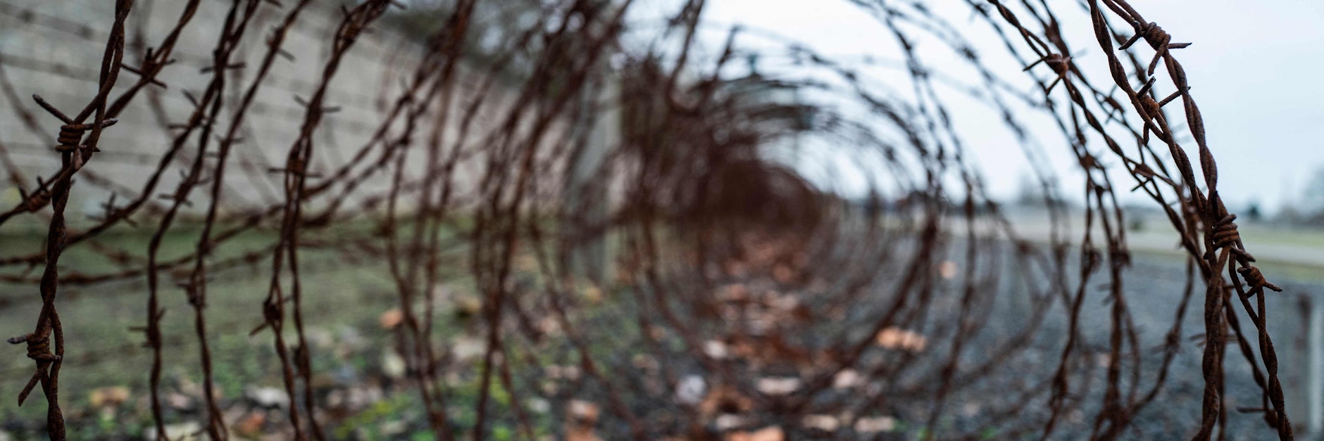 Stacheldraht vor den Mauern im ehemaligen Konzentrationslager Sachsenhausen.